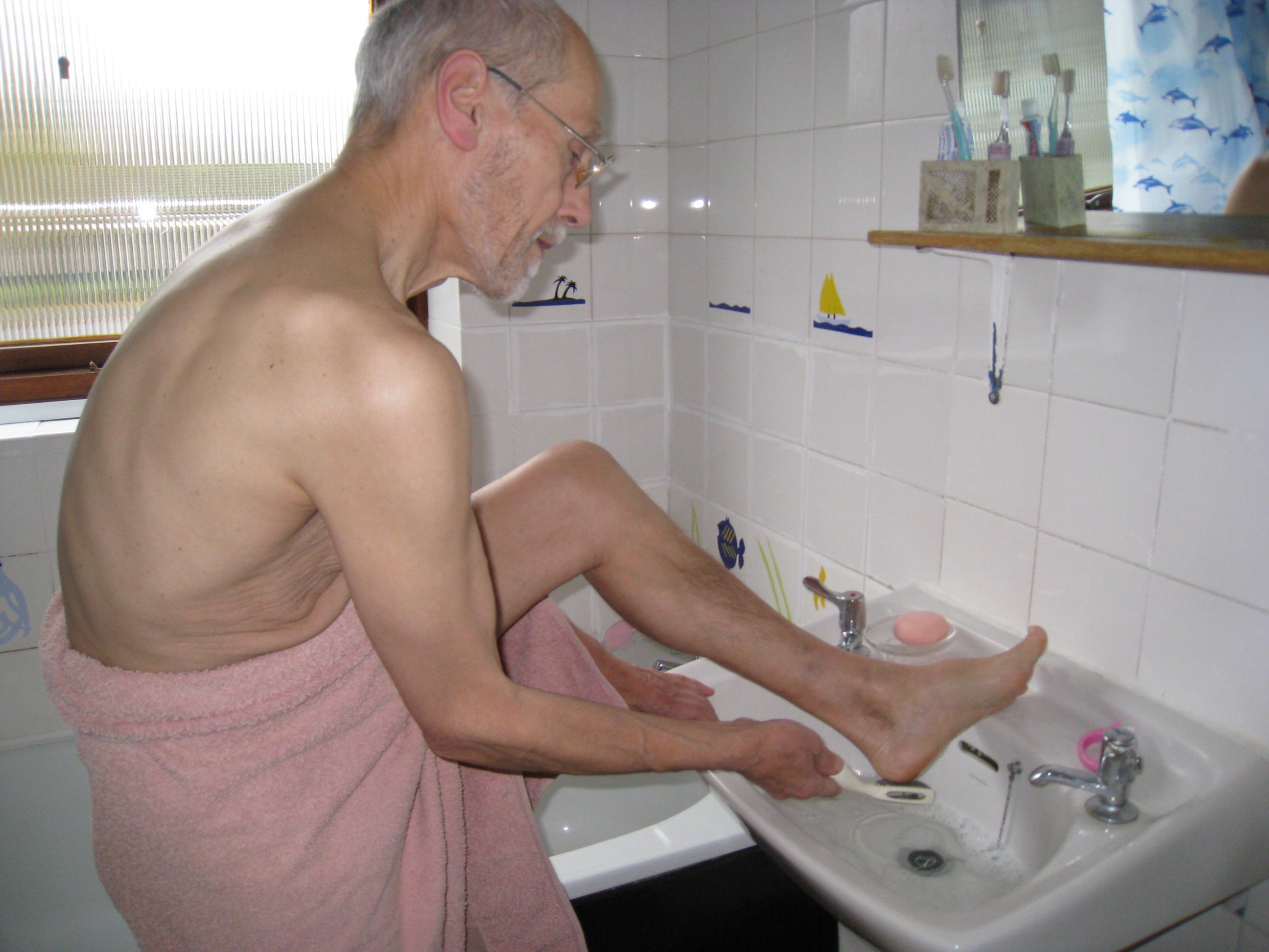 Feet being washed in a basin during routine foot care