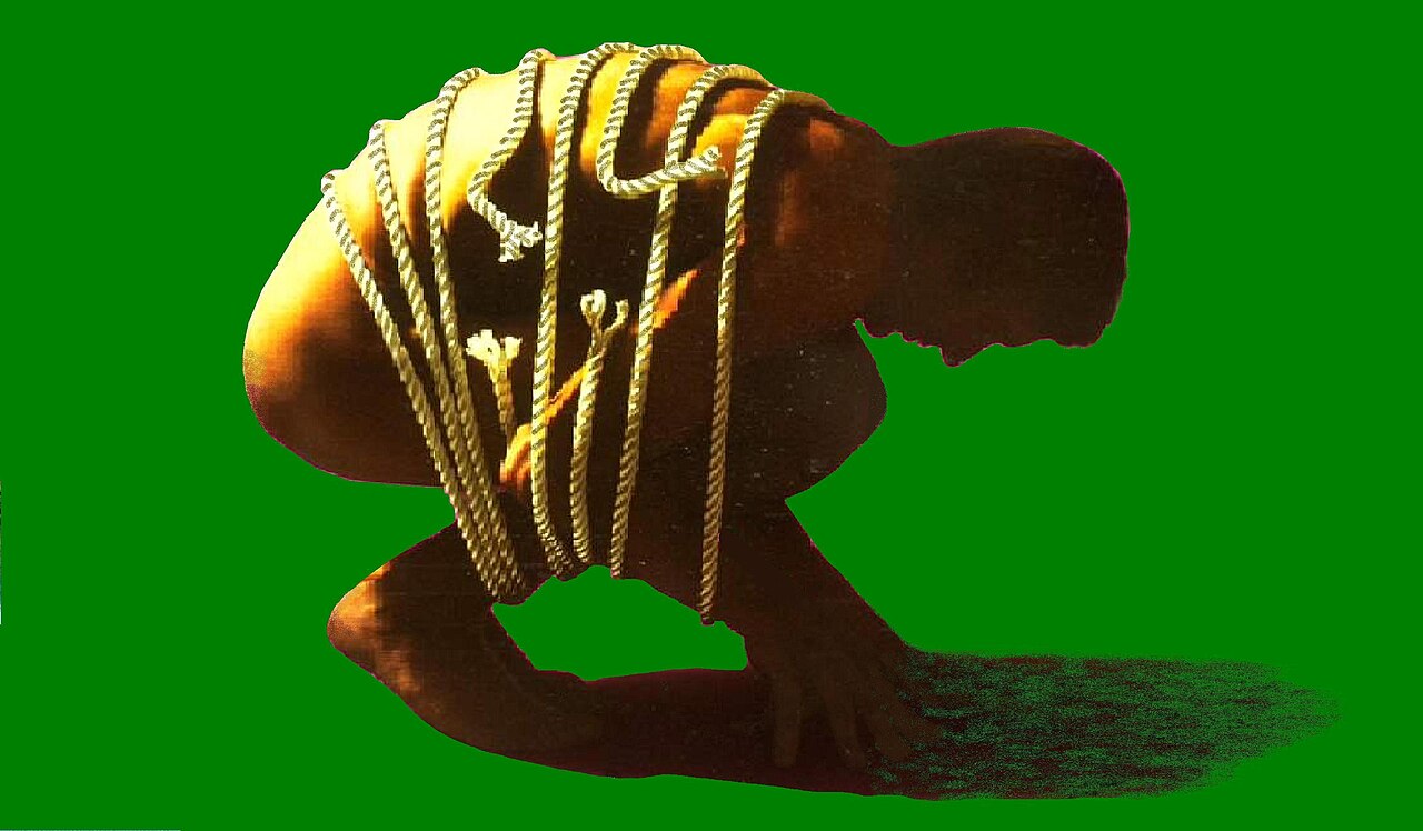 A seated adult holding their lower back because bending is painful