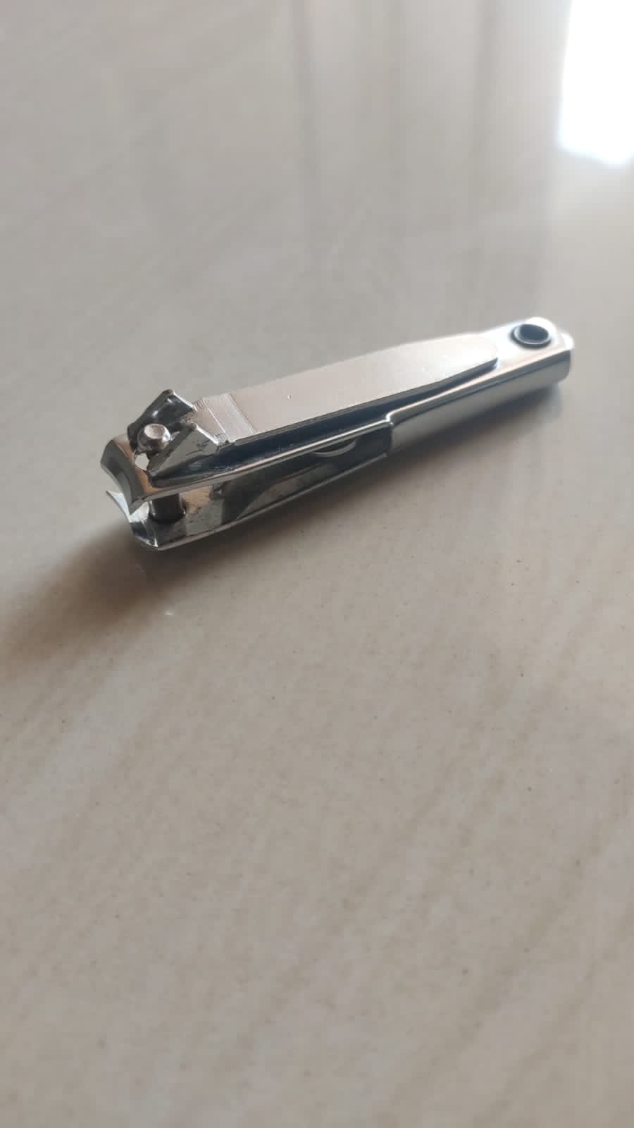 A nail cutter photographed close up on a plain background