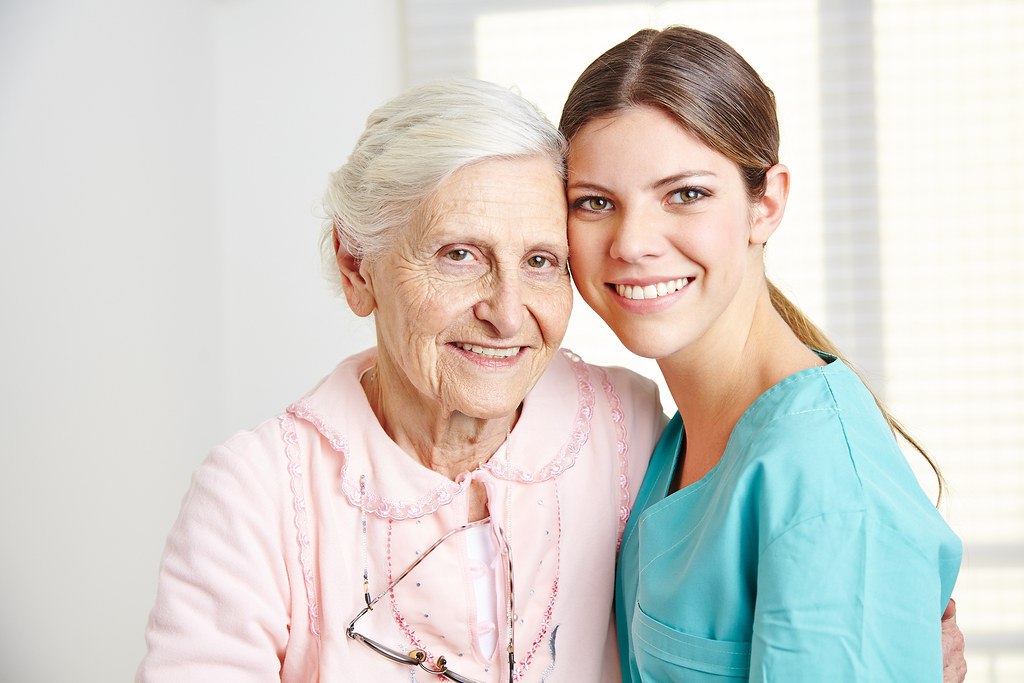 An older adult with a family member and caregiver