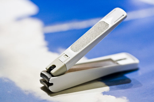 A pair of nail clippers on a plain surface