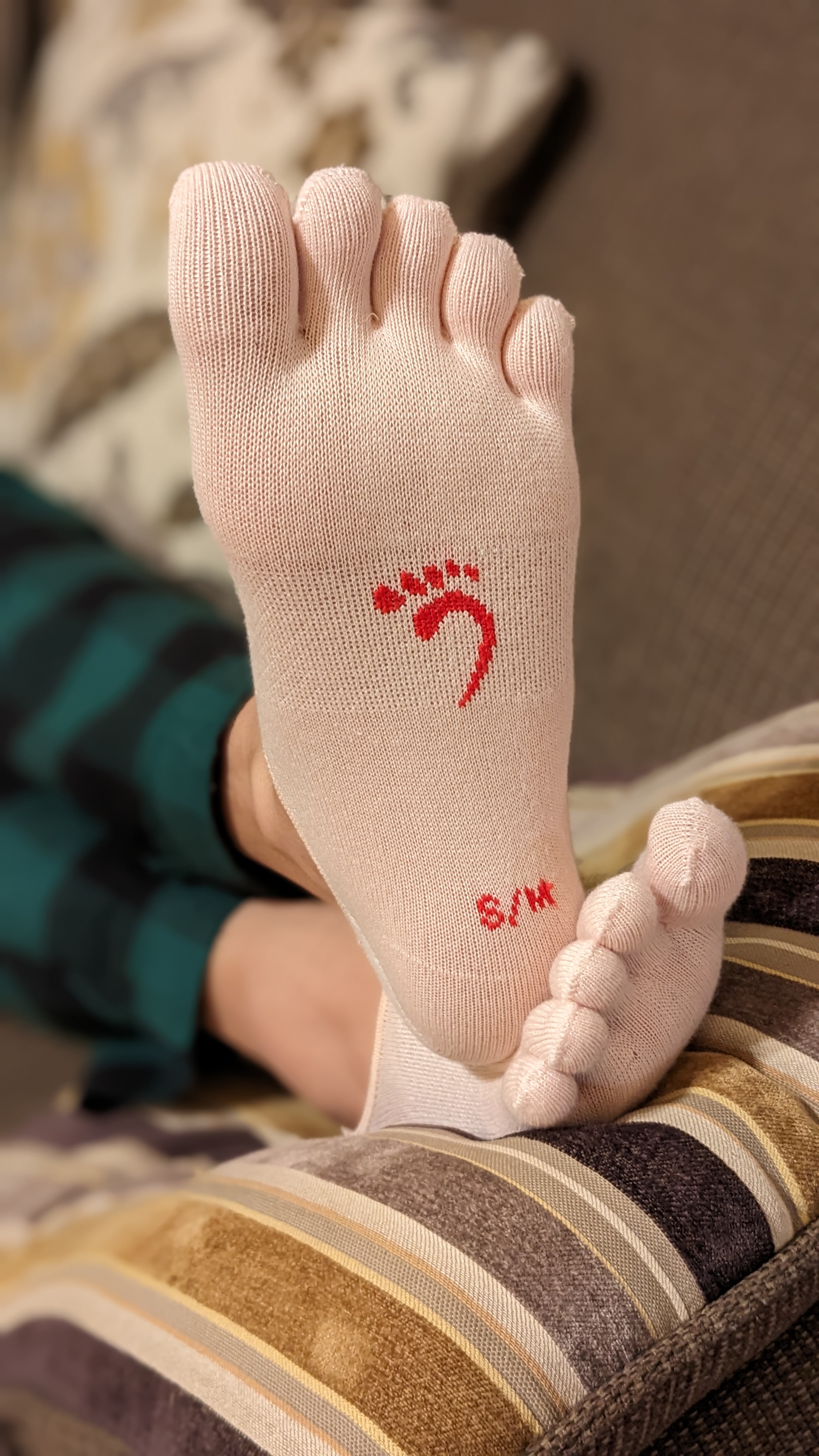 Foot in toe socks resting on a cushion after pressure between toes
