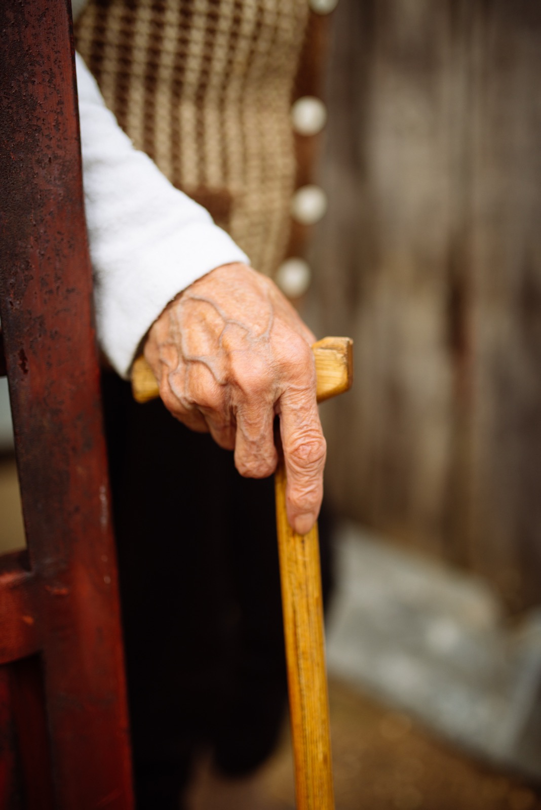 An older person holding a walking stick, showing why foot care at home can be safer when mobility is reduced