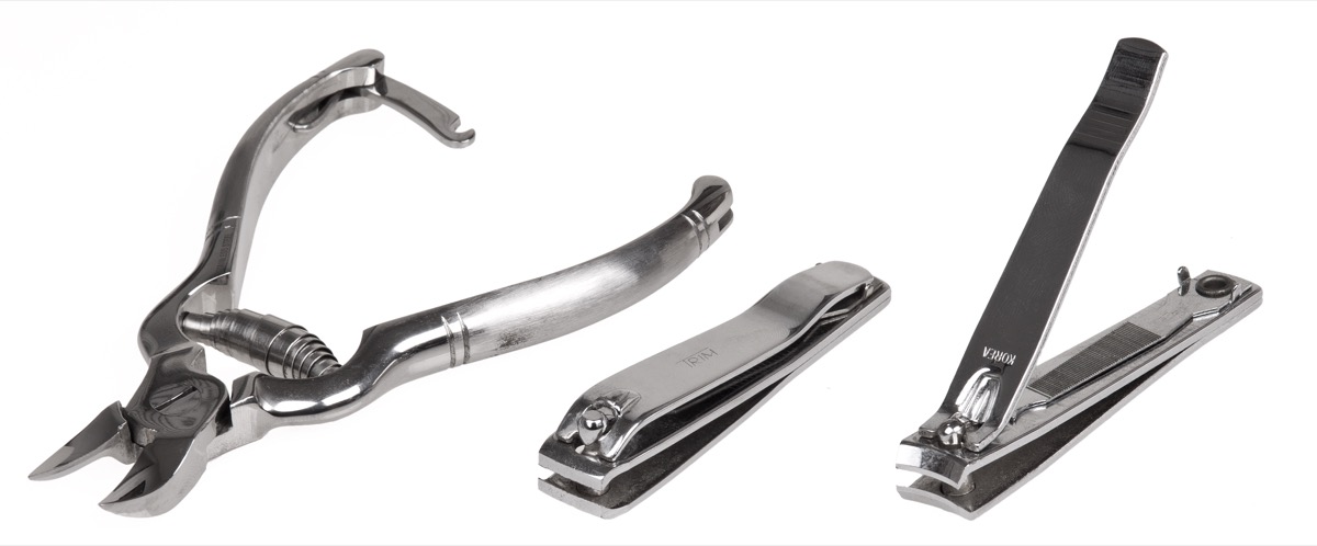 A group of nail clippers on a plain background