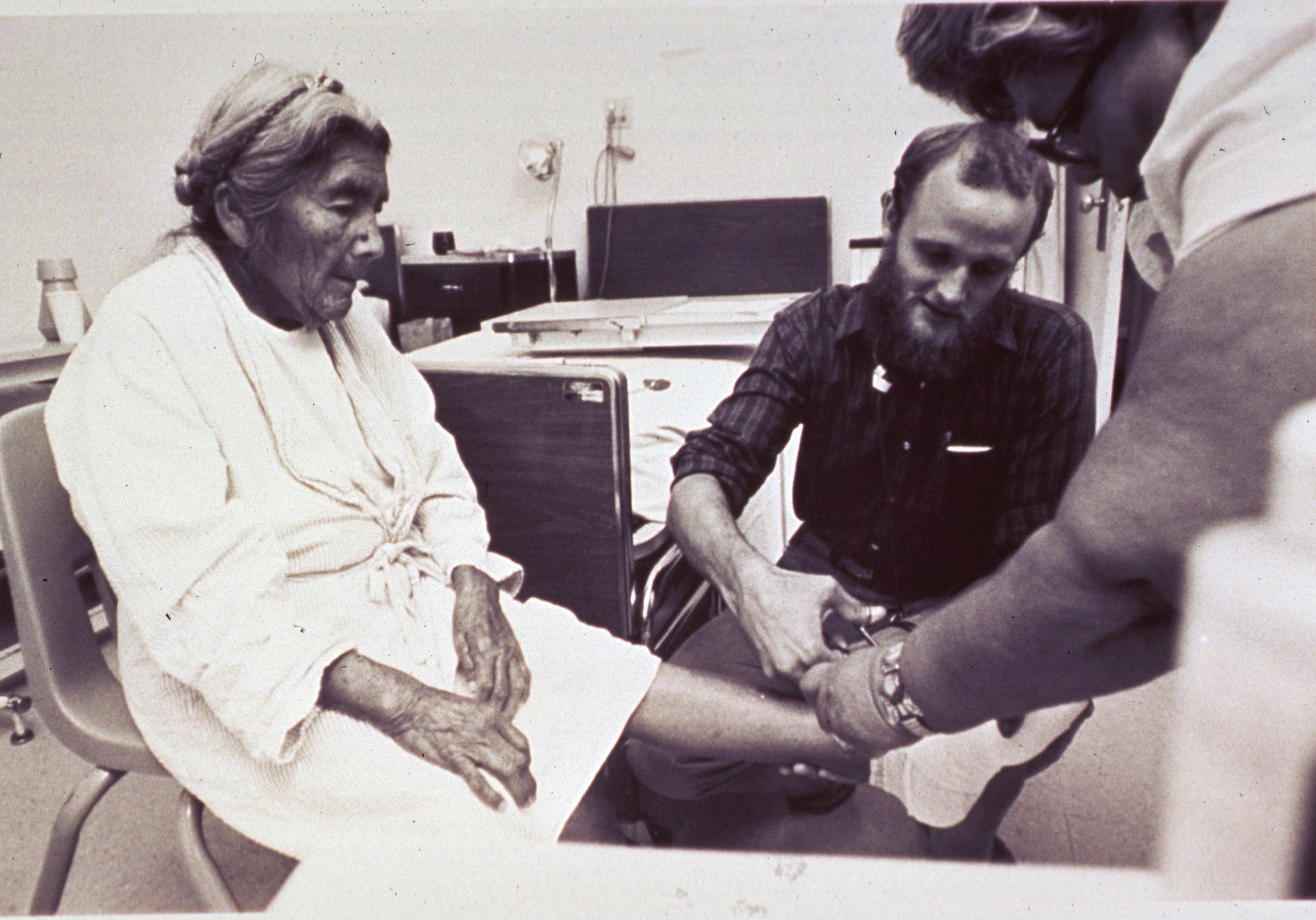 Healthcare professional treating the foot of an older woman during a seated appointment