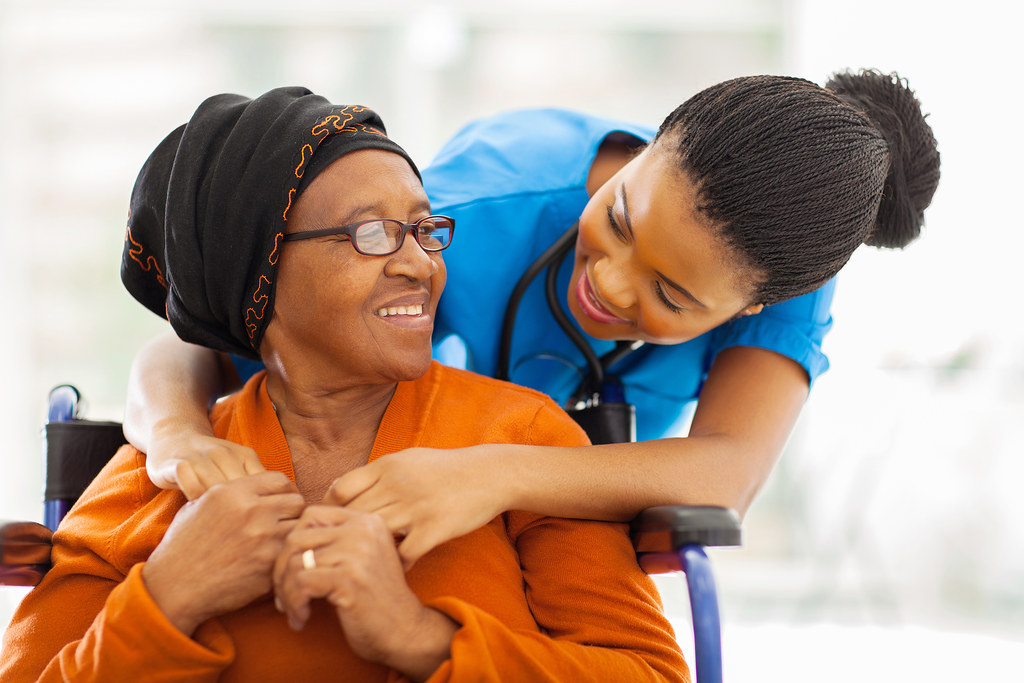 An older patient speaking with a healthcare worker