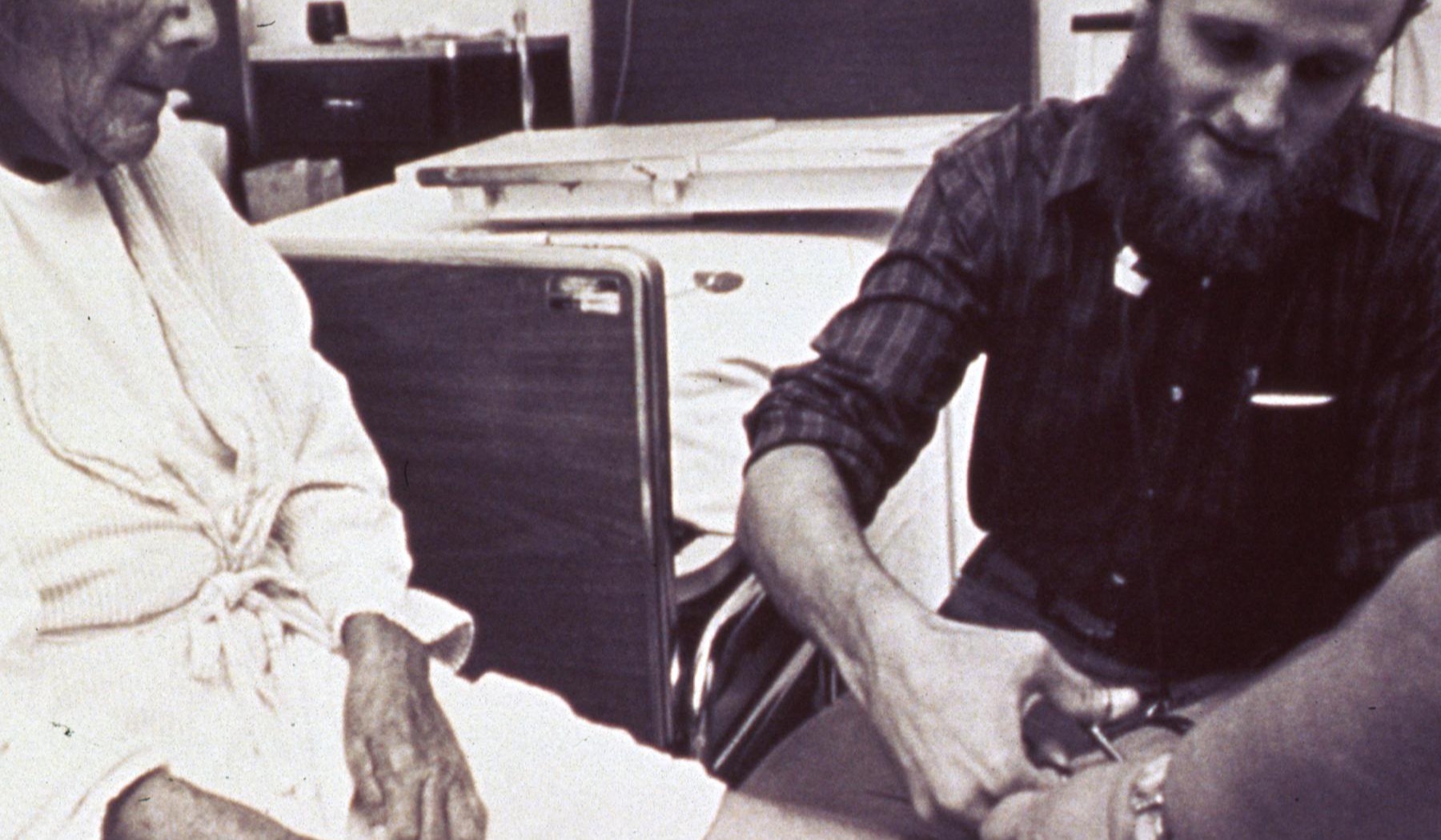 A foot care professional checking an older person's foot during a seated appointment