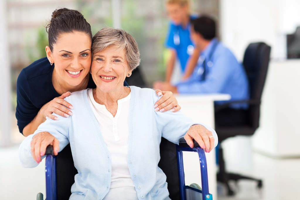 An adult daughter supporting an older person at an appointment, reflecting the carer role in arranging home foot care