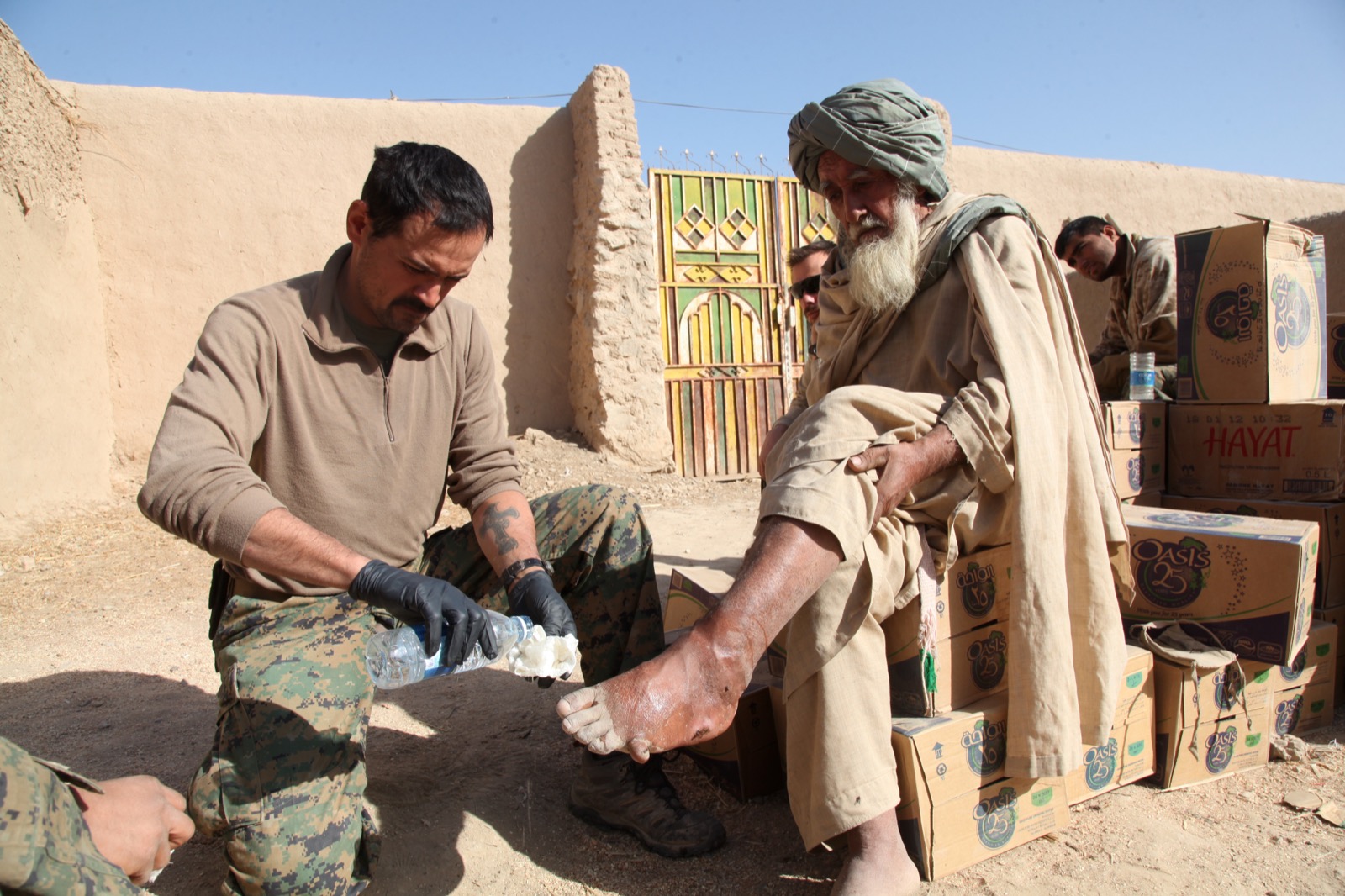 A clinician checking an older man's foot during a foot health assessment