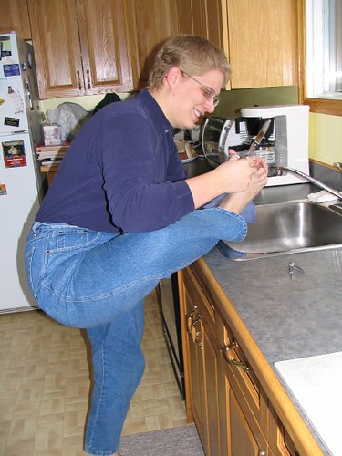 A person carefully reaching to trim a toenail at home, showing why checking first matters