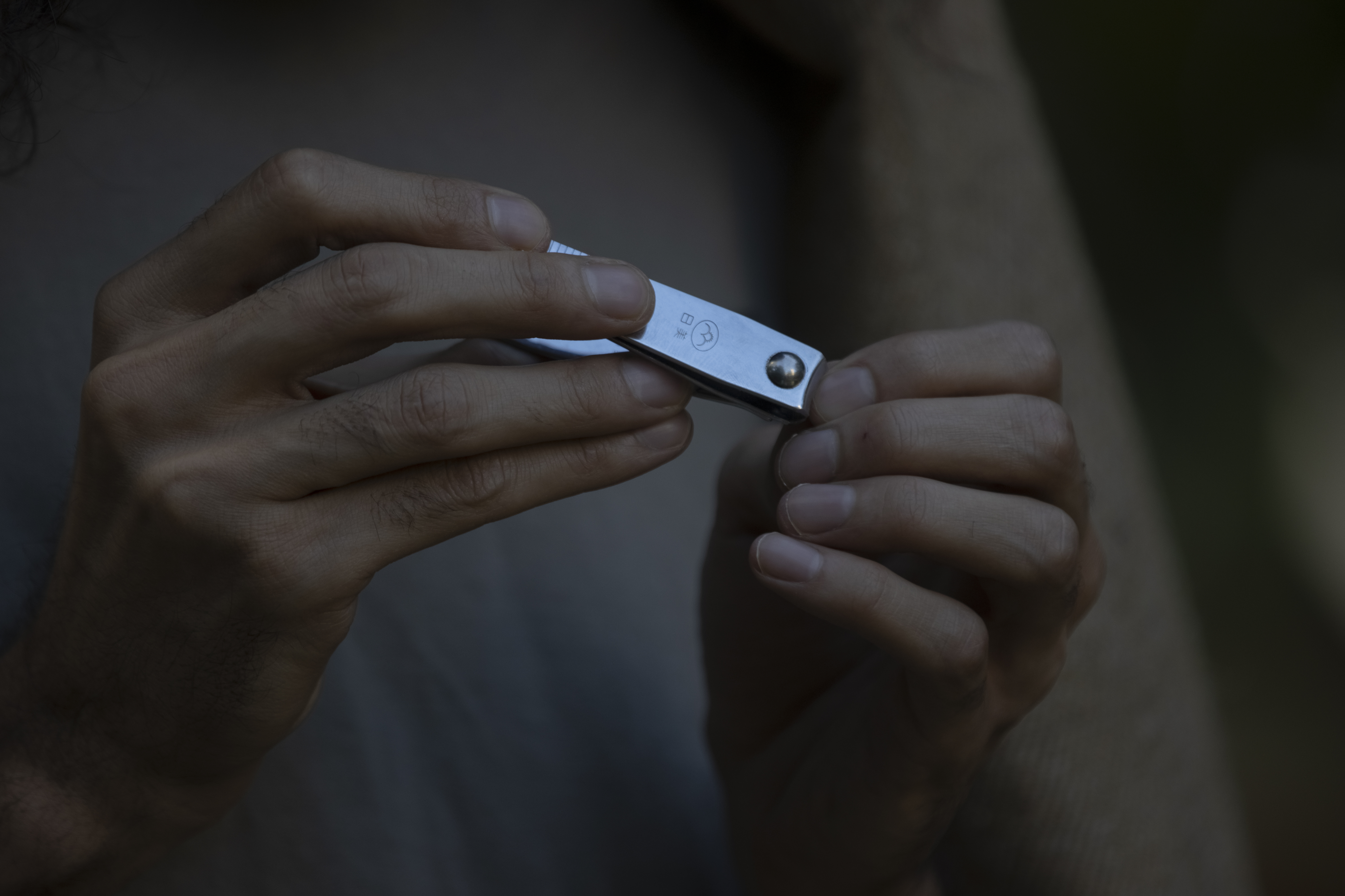 A person using nail cutters, used to show why careful positioning and steady control matter
